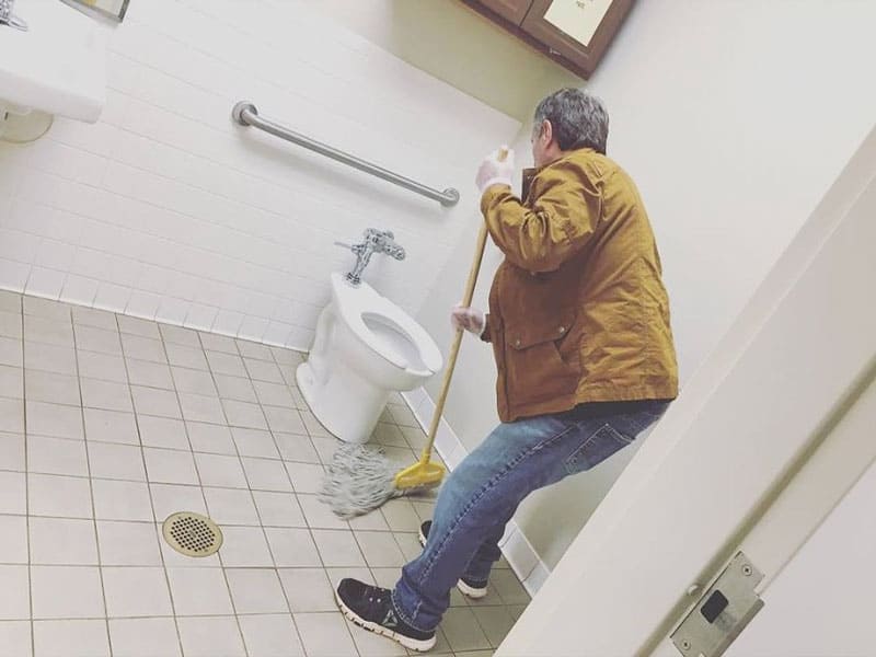 man mopping a bathroom