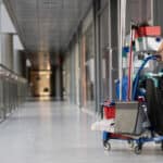 person holding a cleaning cart in an office building